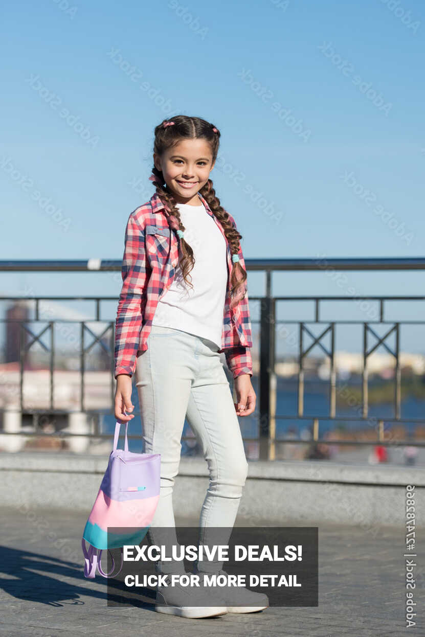 Cute and stylish. Little girl with long tails of hair in casual ...