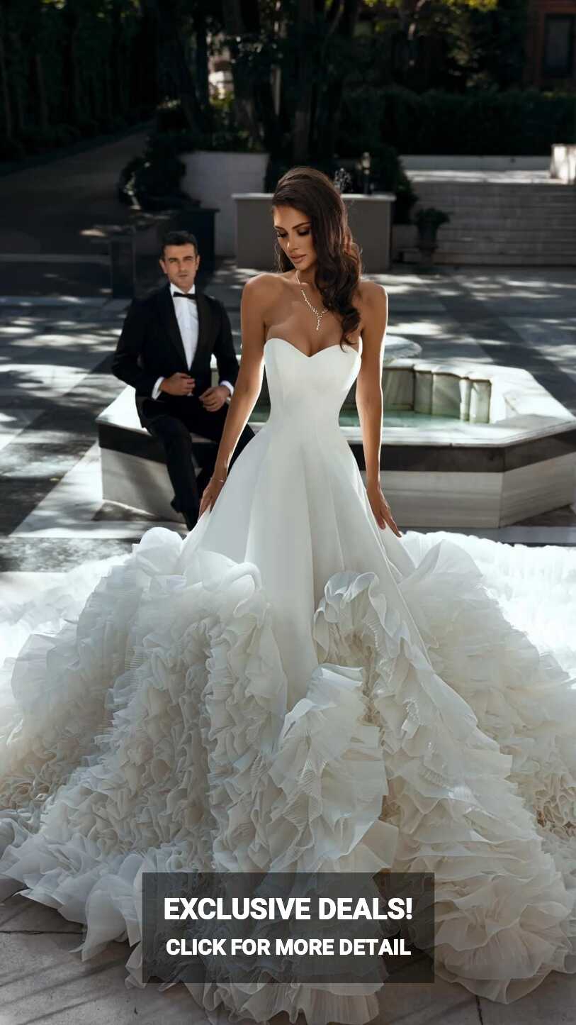 Elegant white dress with a long train. Dress with ruffles. Wedding ...