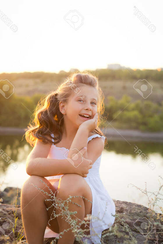 A Small Smiling Girl With Curly Brown Hair Dressed White Short ...