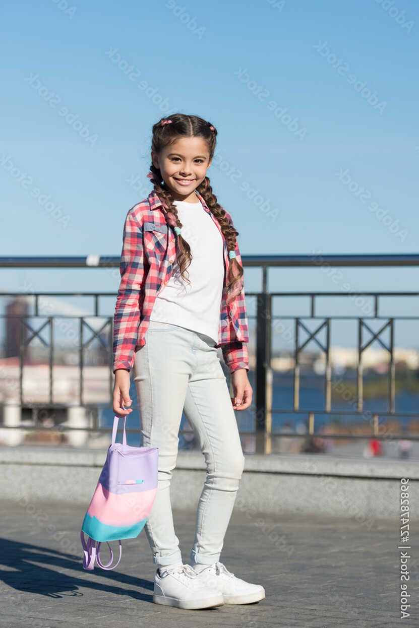 Cute and stylish. Little girl with long tails of hair in casual ...