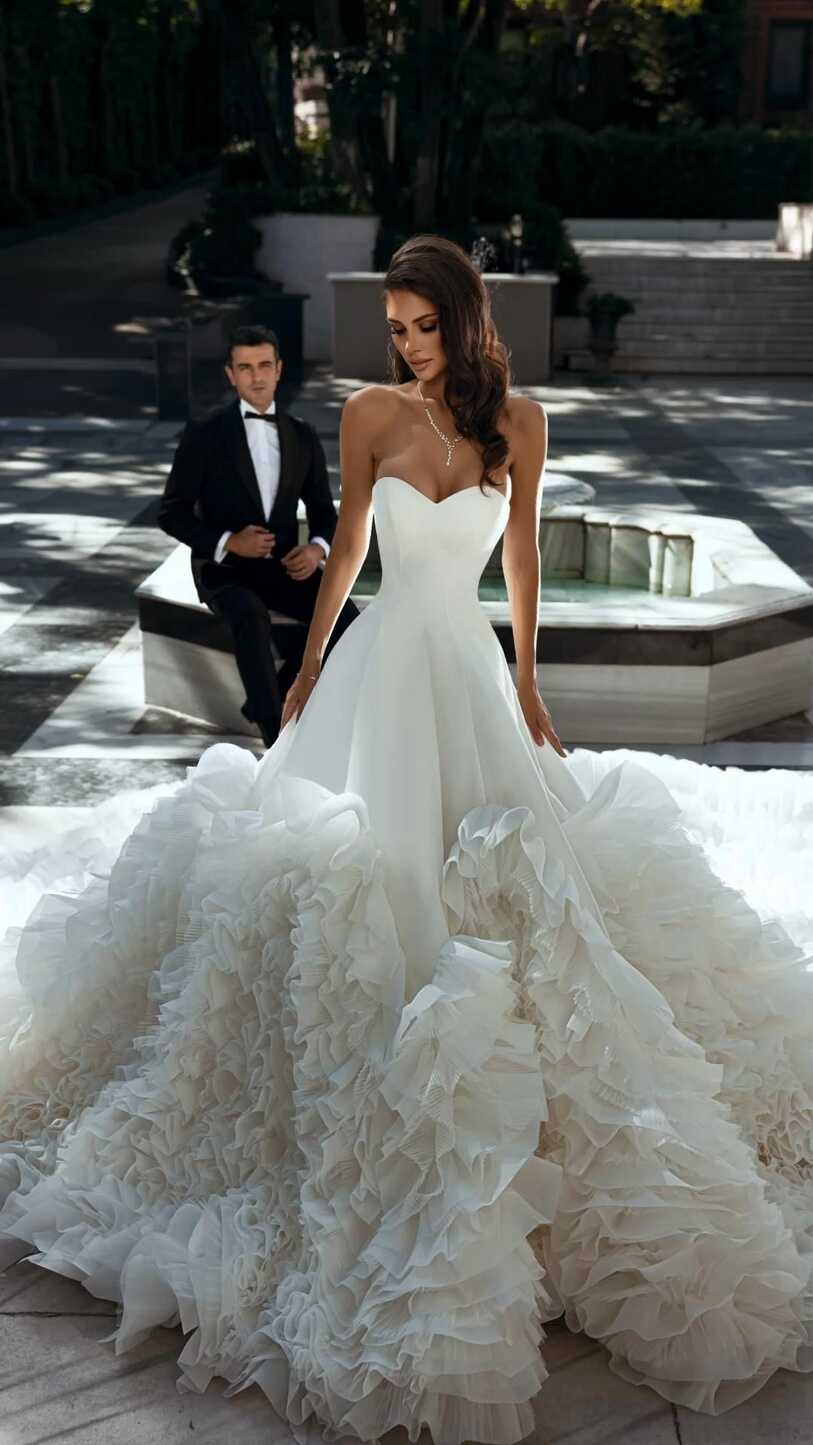 Elegant white dress with a long train. Dress with ruffles. Wedding ...