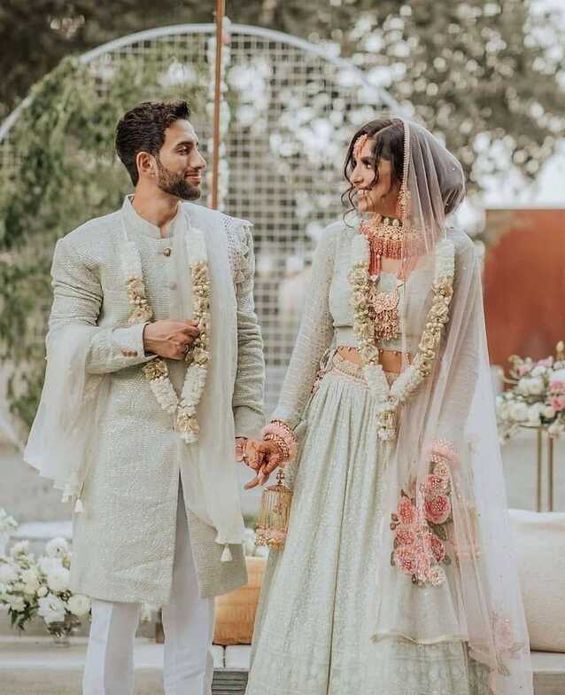 Off-white coordinated couple wedding outfits.